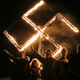 Members of the National Socialist Movement, one of the largest neo-Nazi groups in the U.S., hold a swastika burning after a rally on April 21, 2018, in Draketown, Ga.